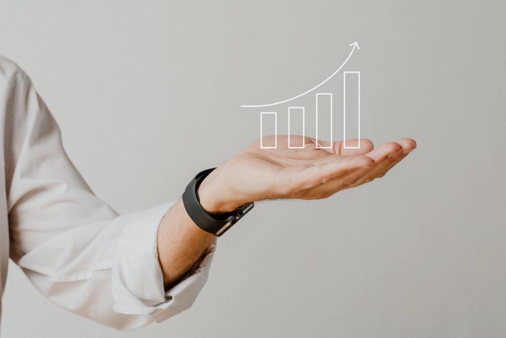 Presenting arm isolated on beige Digital increasing bar graph with businessman hand overlay